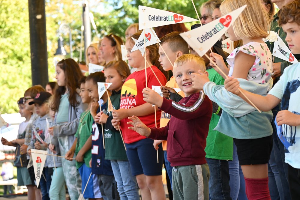 students hold CelebratED MHT pennants on stage during the 2022 festival