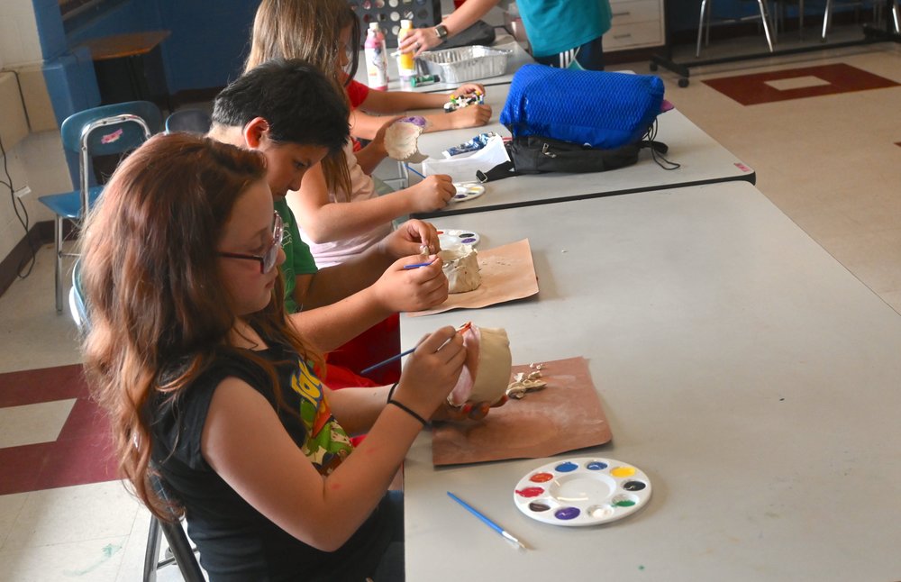 students in Power Scholars program paint pottery during enrichment time