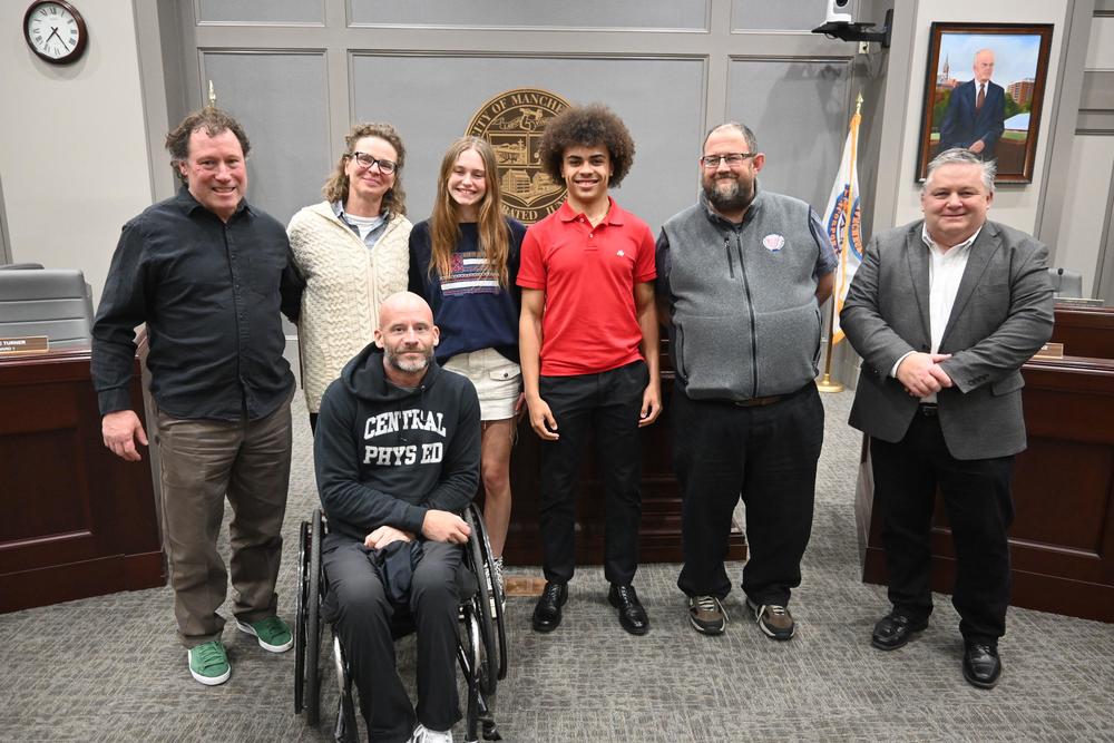 Track and field state champions pose for a photo with coaches at Board of School Committee meeting