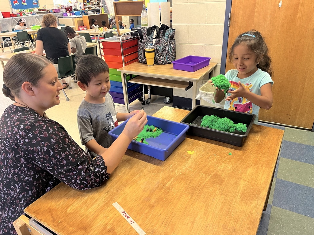 teacher in the Blast Off to Kindergarten program plays with students using kinetic sand 